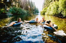 group of friends tubing on the river in summer