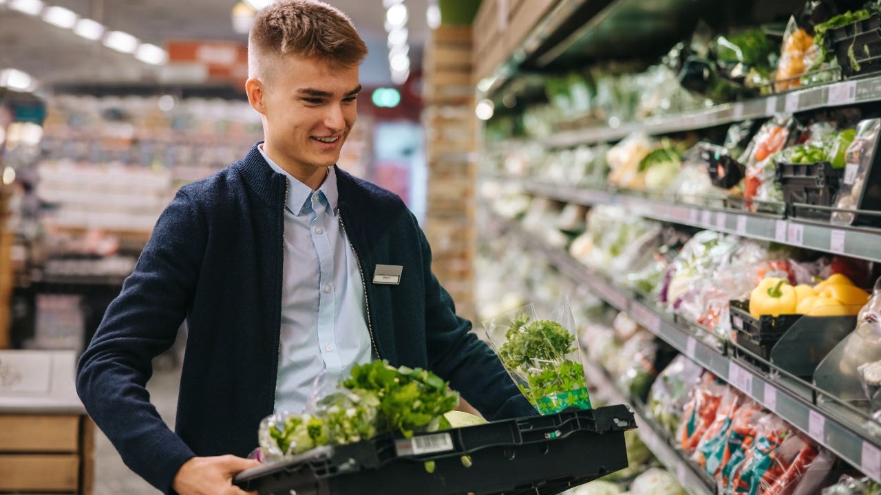 Grocery store employee restocking shelves