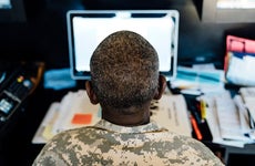Black soldier using computer