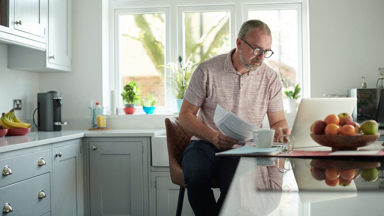 Man works on laptop in kitchen