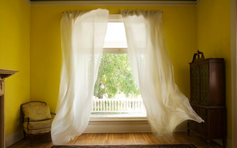 A breezy room with a flowing curtain