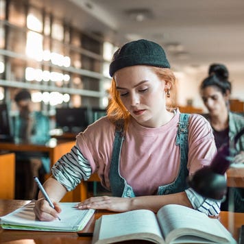 College student works on homework in library