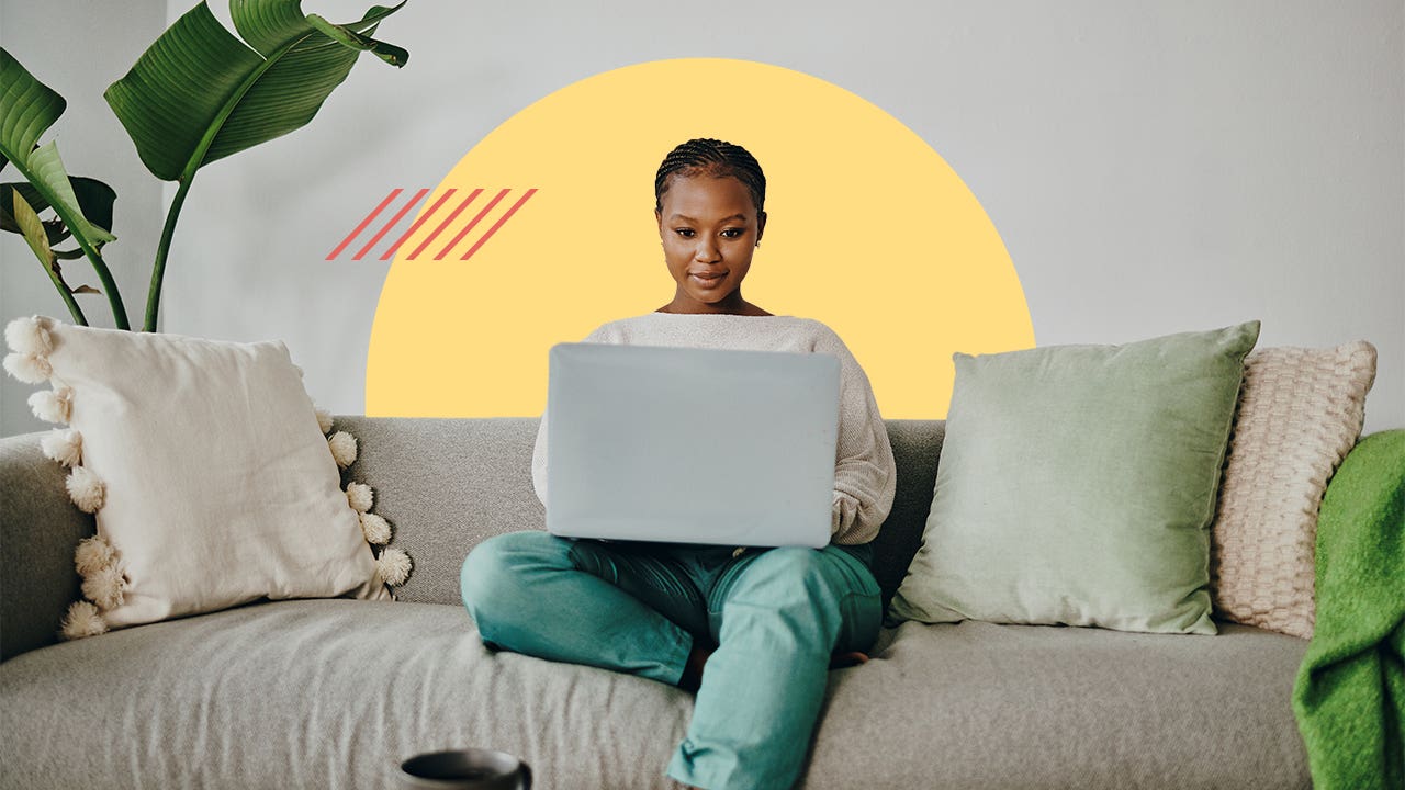 Young woman doing banking from her couch on a laptop
