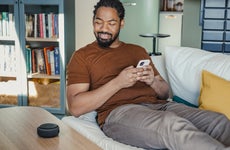 Person sitting on a couch staring at their smart home device