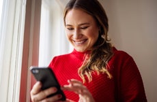 Woman texting on her smart phone and smiling