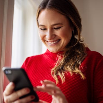 Woman texting on her smart phone and smiling