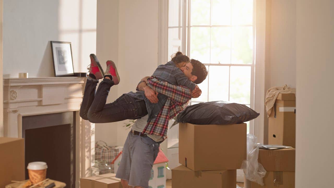 Two people hugging, surrounded by moving boxes