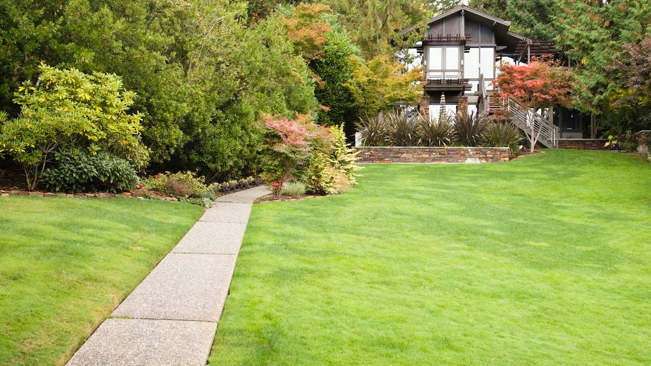 A sidewalk leading to a house in the distance