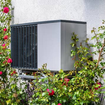 A heat pump located on the side of a home