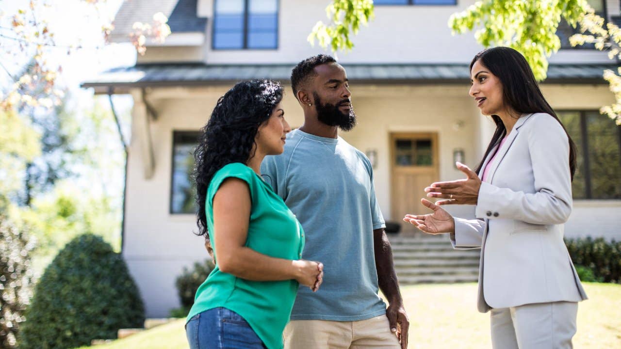 Speaking to a real estate agent in front of a home