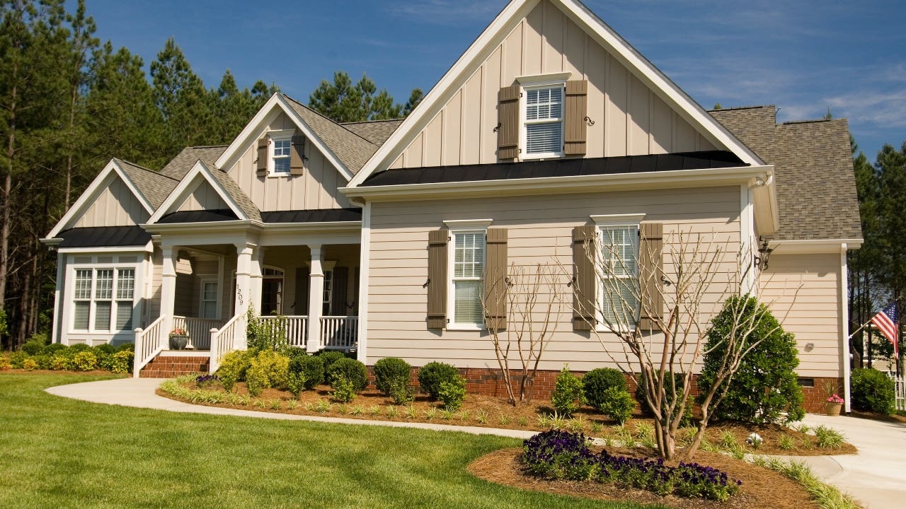 A residential. home with dormers and landscaping