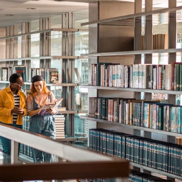 Two students walk through college library