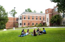 students in a college campus sitting down chatting