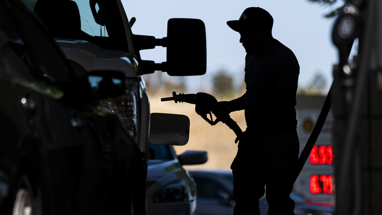 A customer holds a fuel nozzle at a Shell gas station in California
