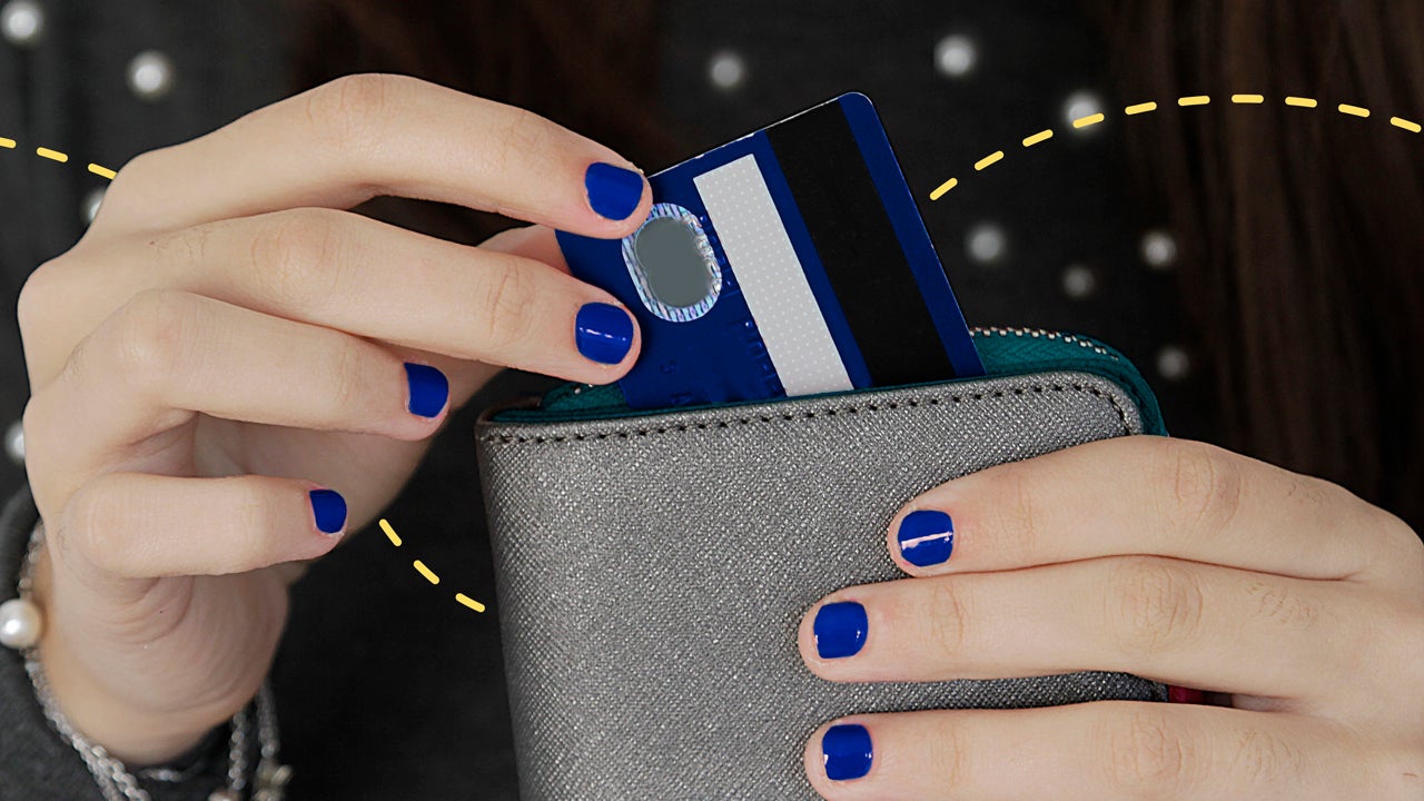 a person with blue painted nails is pulling out a credit card from their wallet