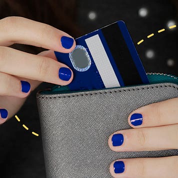 a person with blue painted nails is pulling out a credit card from their wallet