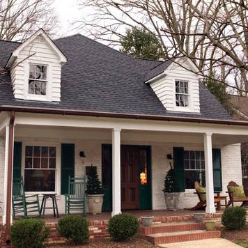 A house with rocking chairs on the porch