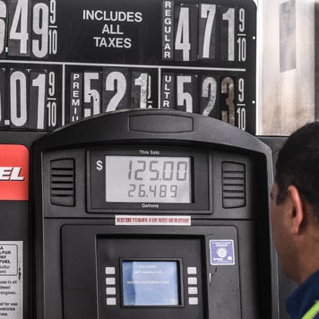 A man fills up his gas tank at high gas prices