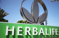 An Herbalife sign and the company's metal logo