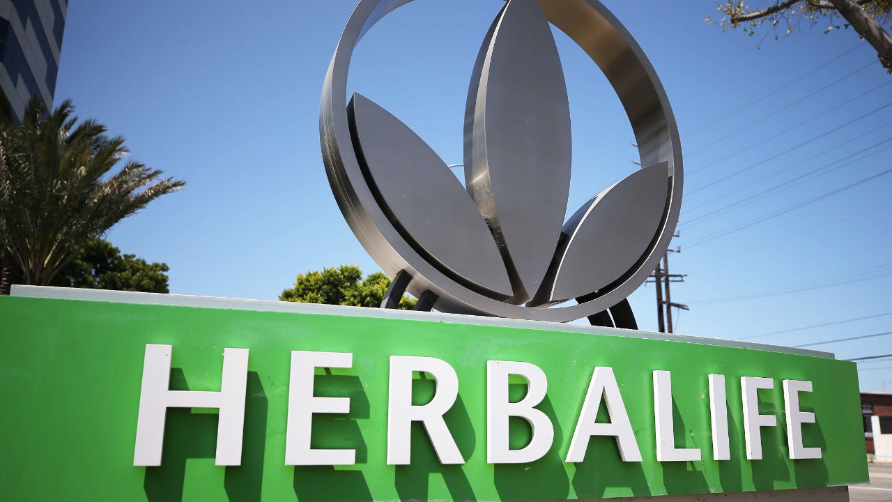 An Herbalife sign and the company's metal logo
