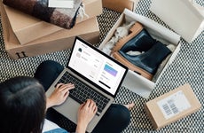 woman online shopping surrounded by boxes