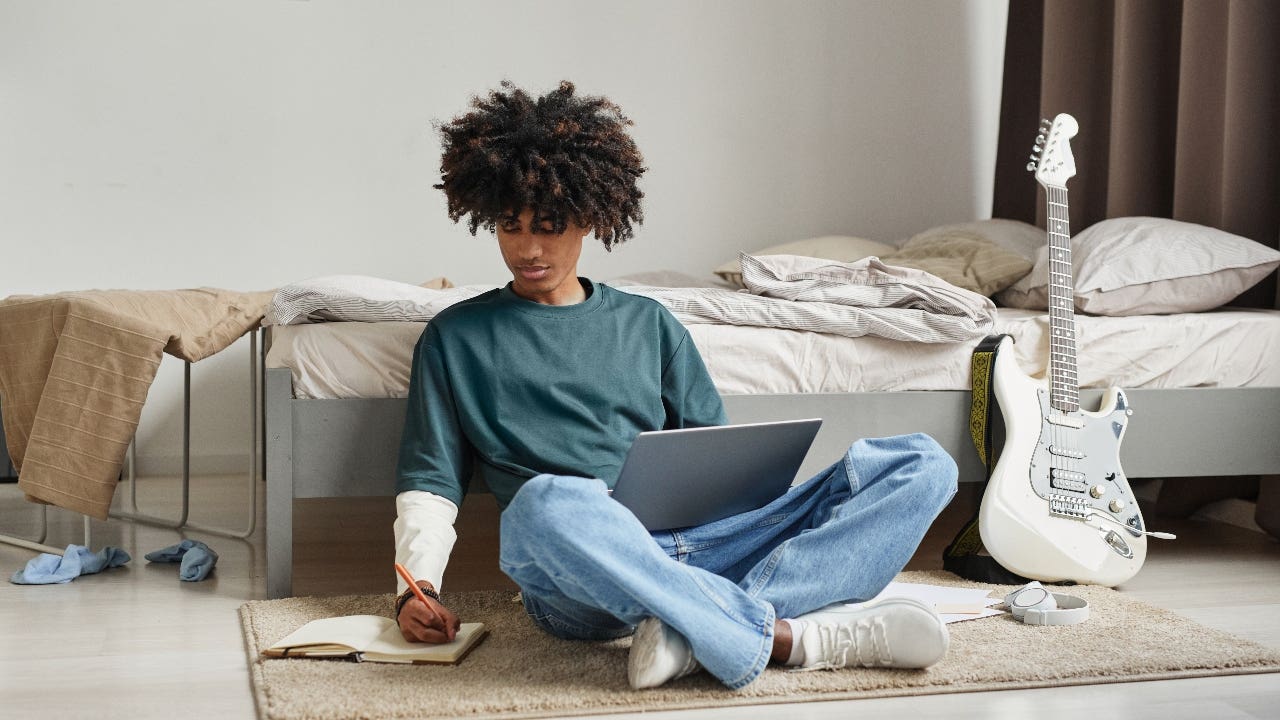 College student studies on floor of bedroom