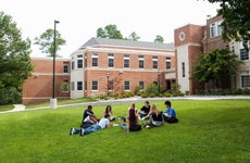 College students sit on the lawn of campus