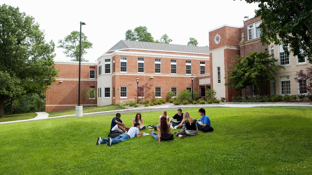 College students sit on the lawn of campus