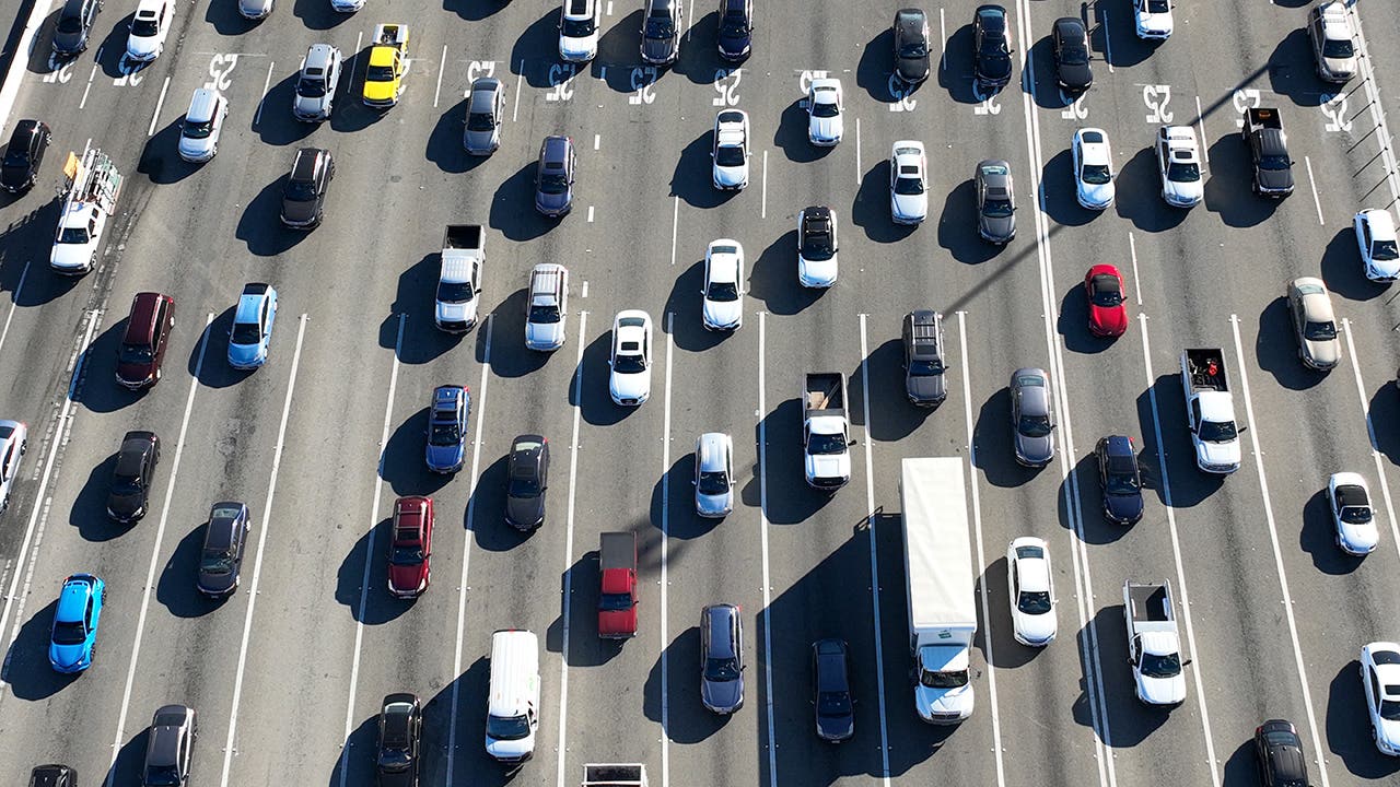 Top down view of several lanes of traffic and cars and trucks filling them.