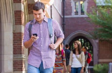 College student walks on campus with a phone