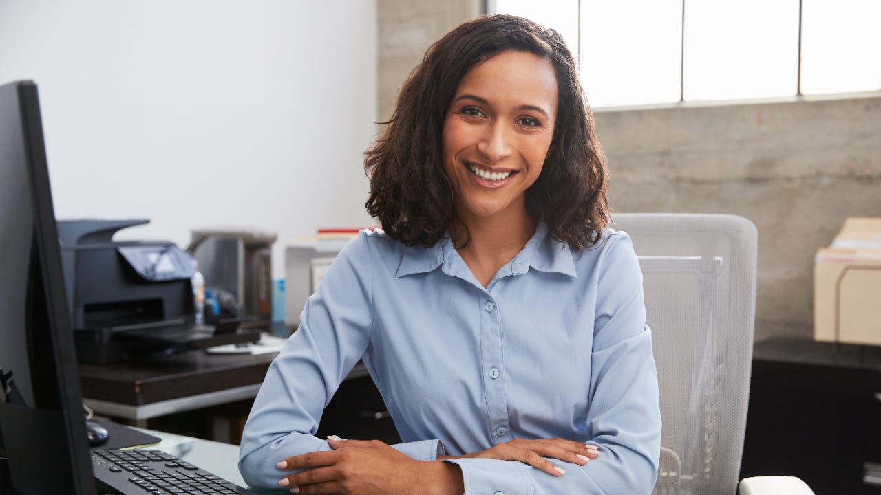 A smiling woman at an office desk