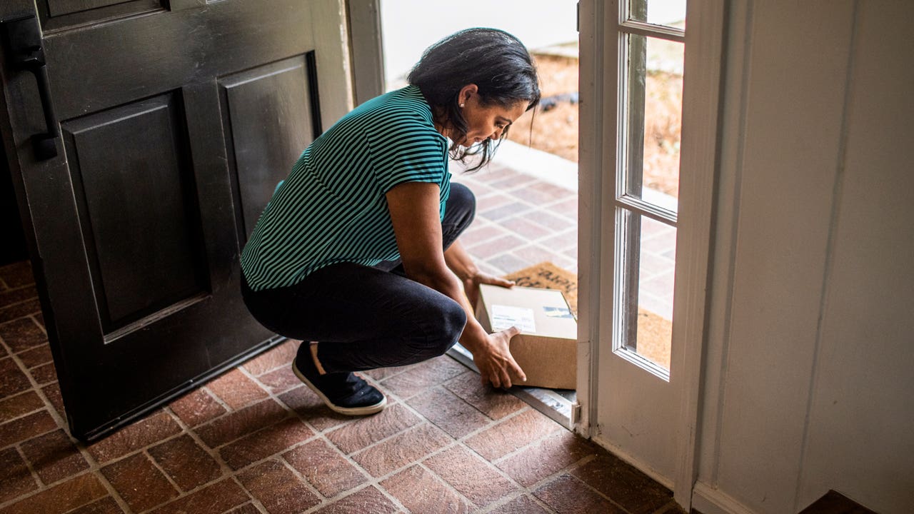 person at door step picking up an amazon box