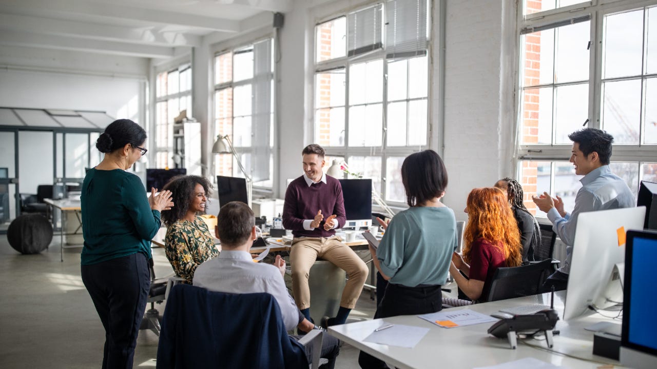 A group of employees meet in their office