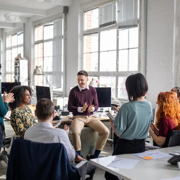 A group of employees meet in their office