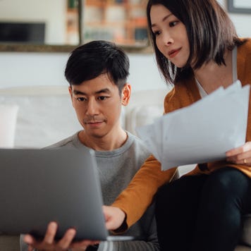 Couple looking at laptop while sitting at home