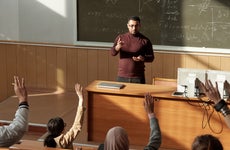 College professor stands at the front of a lecture hall