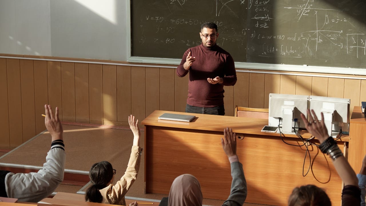 College professor stands at the front of a lecture hall