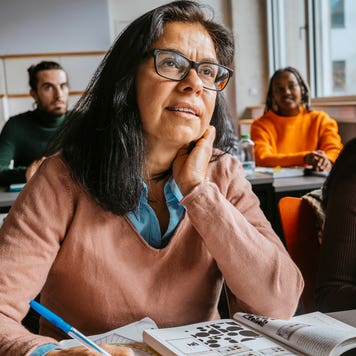 older person at a desk looking to front of room