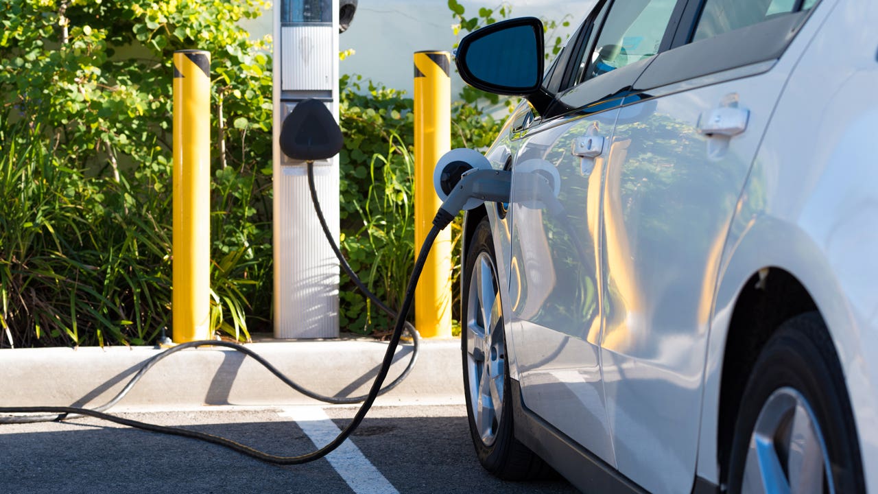 an electric vehicle charging at a charging station