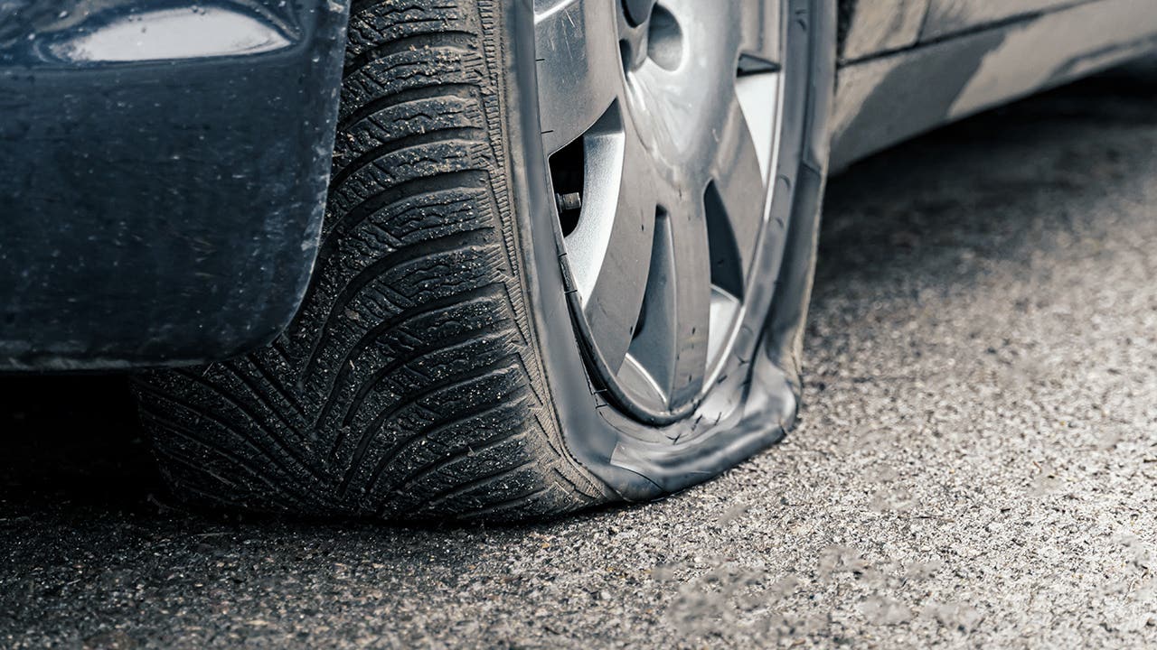 flat car tire close up, punctured wheel