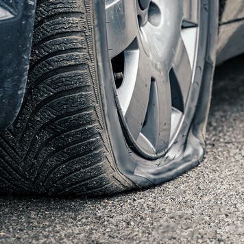 flat car tire close up, punctured wheel