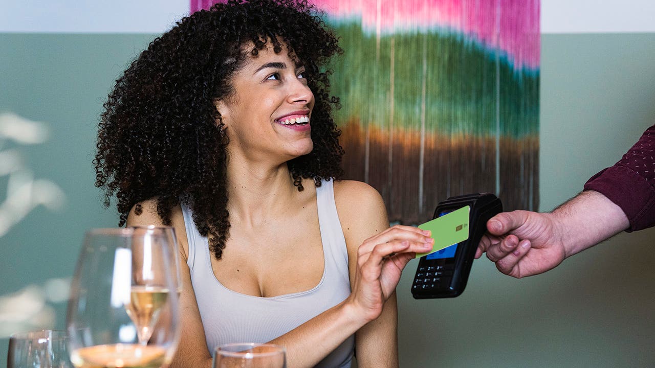 Smiling woman paying through credit card at restaurant