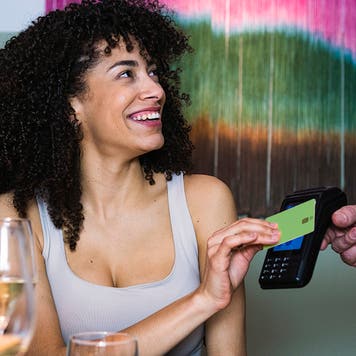 Smiling woman paying through credit card at restaurant