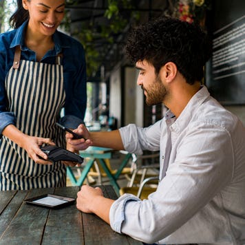 young person paying a dining bill with a card