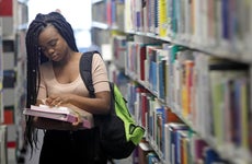 College student looks at books in the library
