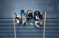 Students sit on steps of university building and study