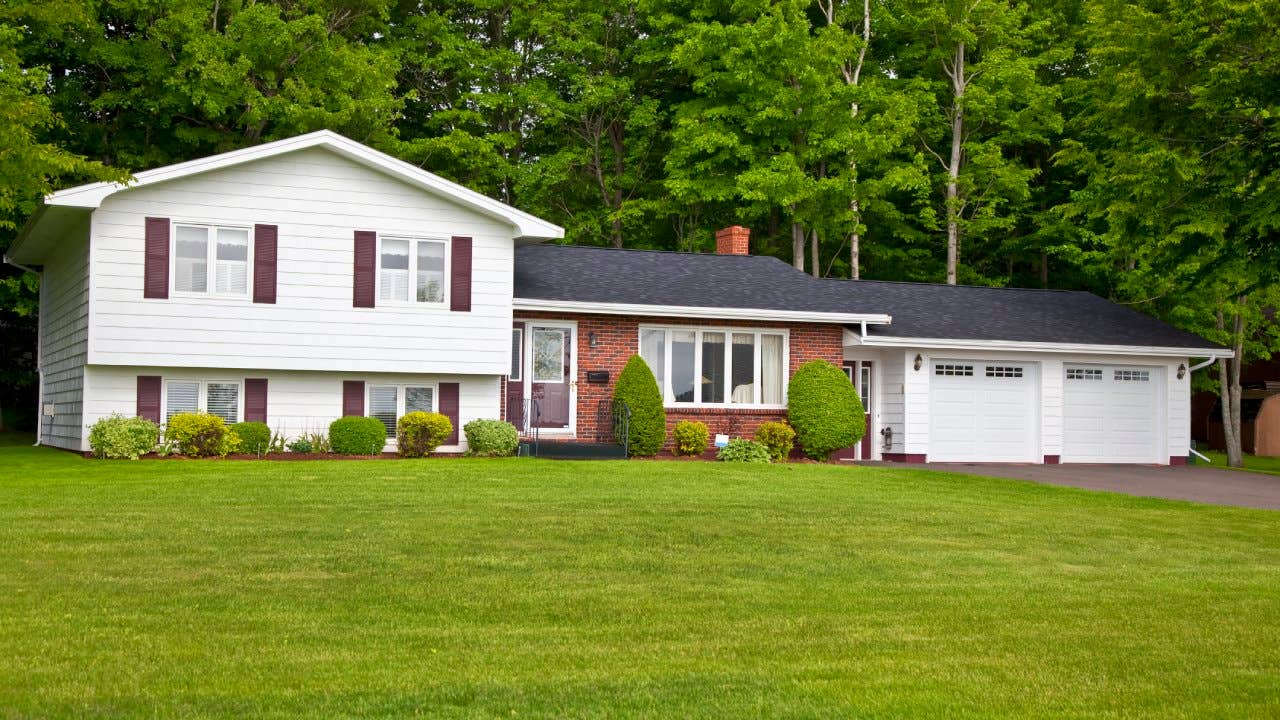 A split-level house surrounded by green grass