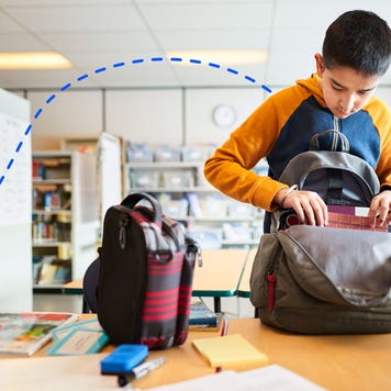a kid packing things into his bookpack
