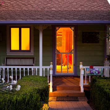 A cottage-style home with lights on in the evening
