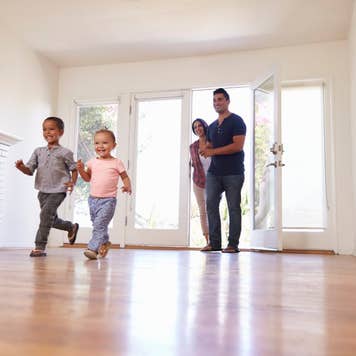 Kids running into a home with hardwood floors.